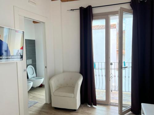 a living room with a chair and a sliding glass door at L’ANGELO BIANCO in Pula