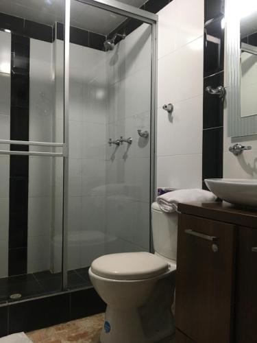 ein Bad mit einer Dusche, einem WC und einem Waschbecken in der Unterkunft Hotel Ejecutivo Av la Esperanza in Bogotá