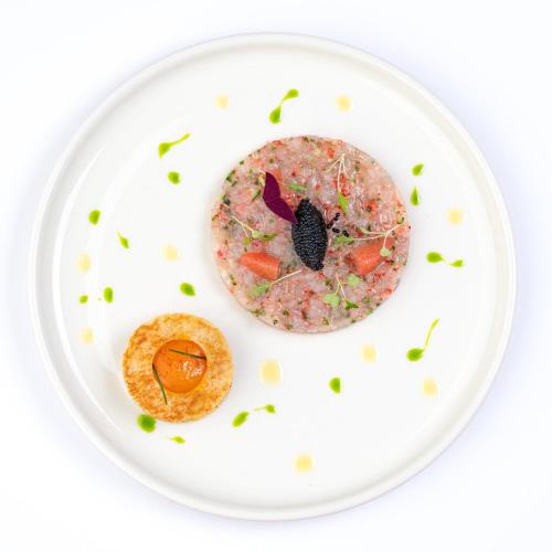 a white plate with a donut on it at Hotel Meridian in Cluj-Napoca