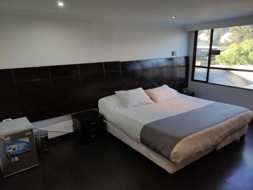 a bedroom with a large bed and a window at Hotel Ejecutivo Av la Esperanza in Bogotá