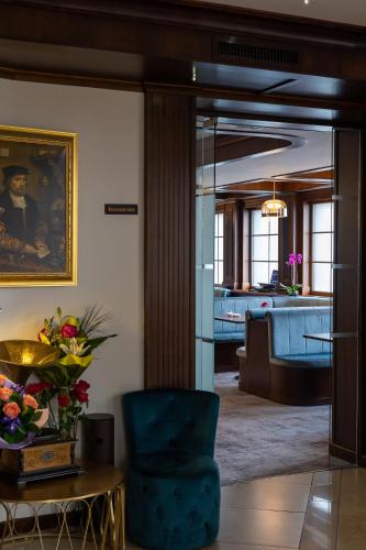 a living room with a blue chair and a table at Hotel Meridian in Cluj-Napoca