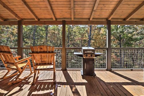 a grill on a screened in porch with two chairs at Pigeon Forge Cabin with Hot Tub 1 Mi to Parkway in Pigeon Forge