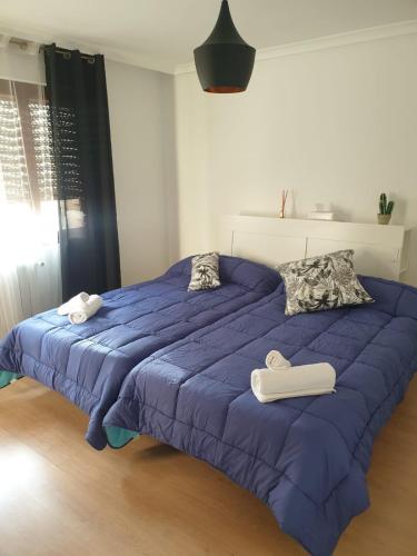 1 dormitorio con 1 cama azul y 2 toallas en Torre Urbanlux, en Albacete