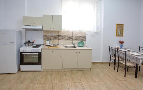 a kitchen with a stove and a sink and a table at HAROULENA in Kavala