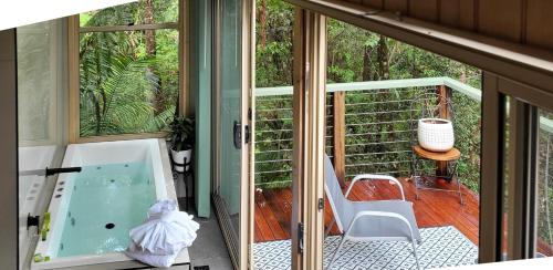 a room with a tub and a chair on a balcony at Treetops Montville in Montville