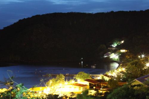 a view of a town at night with the ocean at APPARTEMENT COLIBRI , Les Anses d 'Arlet in Les Anses-dʼArlets
