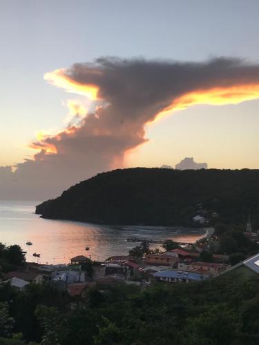 a sunset over a town and a body of water at APPARTEMENT COLIBRI , Les Anses d 'Arlet in Les Anses-dʼArlets