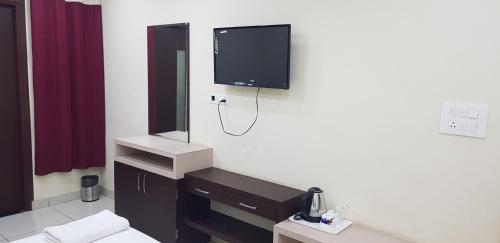 a bathroom with a tv on the wall at Hotel Teeja's - Haldi Restaurant Aiims road Jodhpur in Jodhpur