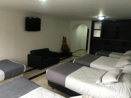 a hotel room with two beds and a television at Hotel Ejecutivo Av la Esperanza in Bogotá