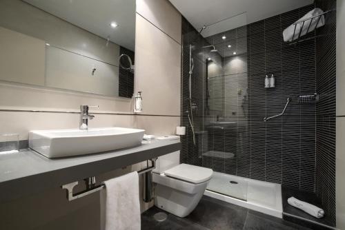 a bathroom with a sink and a toilet and a shower at Hotel Sercotel Tudela Bardenas in Tudela