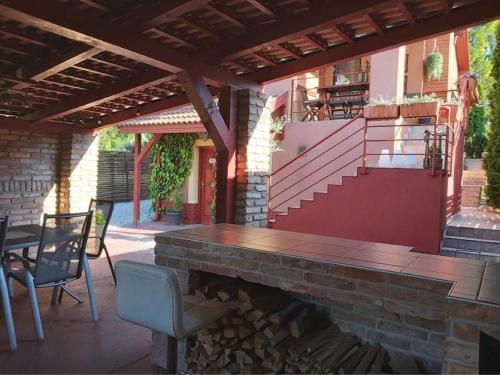 d'une terrasse avec une cheminée, une table et des chaises. dans l'établissement Nyirjes Vendégház, à Balassagyarmat