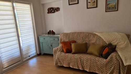 a living room with a couch with pillows on it at Casa da Professora in Vendas de Maria