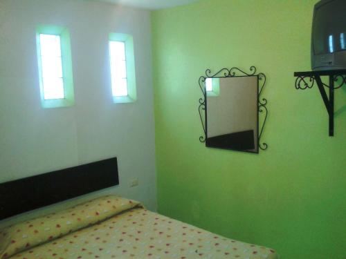 Hotel San Andres في خالابا: غرفة نوم مع سرير ومرآة على الحائط