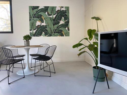 uma sala de jantar com mesa e cadeiras e uma planta em Le Lodge du Chêne, Gîte avec SPA classé 3 étoiles em Vendeuvre-du-Poitou