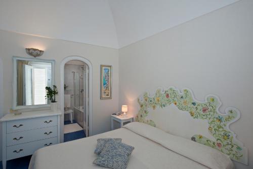 
a bedroom with a bed and a dresser at Villa La Tartana in Positano
