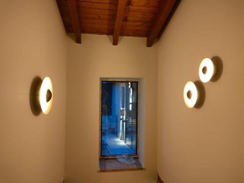 two lights on the wall of a room with a mirror at Domus Oncinae in Oncina de la Valdoncina