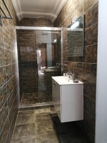 a bathroom with a white sink and a shower at Ikamu's lodge in Germiston