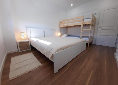 a bedroom with a bunk bed and a wooden floor at Lovely Home, WIFI, Jardim in Armação de Pêra