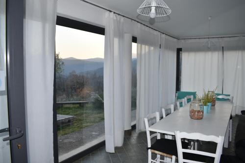 a dining room with a table and a large window at B&B La Montagna Rosa in Castelnuovo