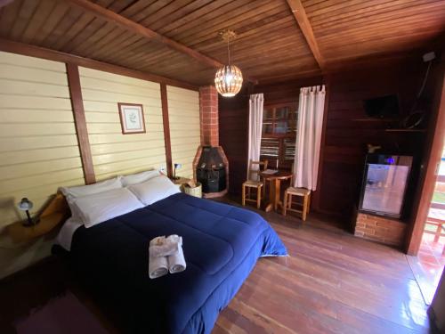 a bedroom with a bed with white shoes on it at Pousada Cabanas do Visconde in Visconde De Maua