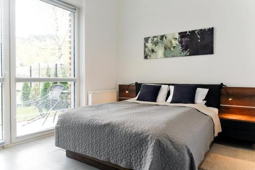 sypialnia z łóżkiem i dużym oknem w obiekcie SKi&bike apartments w Szczyrku