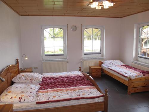 2 camas en un dormitorio con 2 ventanas en Ferienhaus INGE MOOR203 en Südbrookmerland