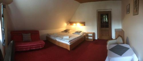 a small bedroom with a bed and a chair at Pension U Háčků in Harrachov