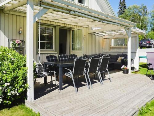 a patio with a table and chairs on a deck at 9 person holiday home in SOLLENTUNA in Sollentuna