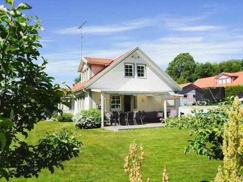 una casa blanca con un patio con césped verde en 9 person holiday home in SOLLENTUNA, en Sollentuna
