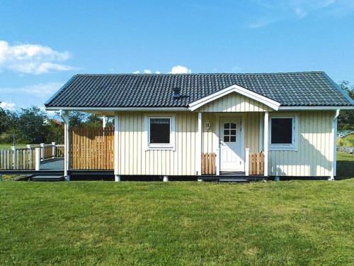 une petite maison blanche avec une clôture dans une cour dans l'établissement 4 person holiday home in Byxelkrok, à Byxelkrok