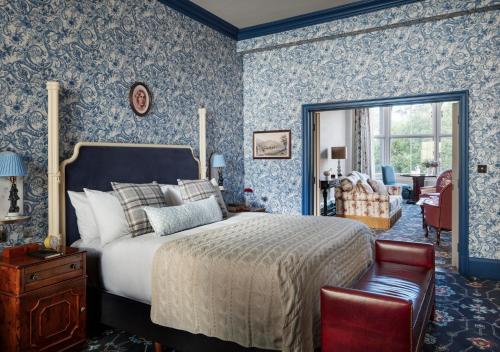a bedroom with a bed with blue wallpaper at The Randolph Hotel, by Graduate Hotels in Oxford