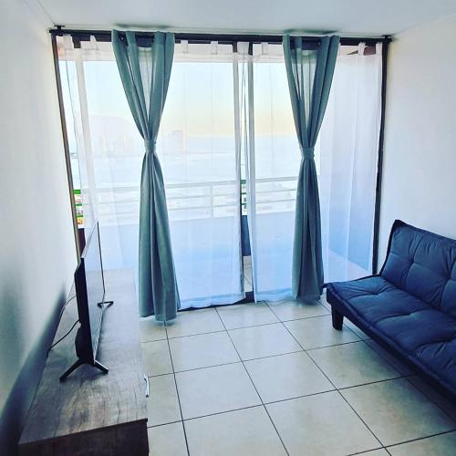 a living room with a couch and a large window at Departamento NEO IQUIQUE VISTA AL MAR 3 in Iquique