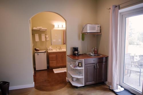 a bathroom with a sink and a refrigerator and a microwave at Baergnaescht B&B in Osoyoos