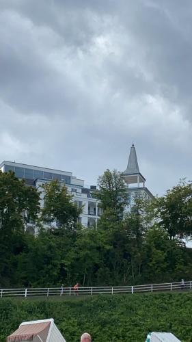 a building with a steeple on top of a hill at Viktoria Deluxe direkter Meerblick in Ostseebad Sellin