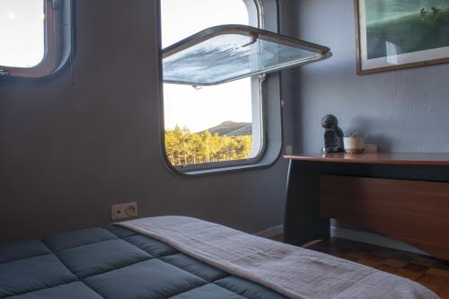 a small bedroom with a bed and a window at Estudio Estación Manzaneda in Puebla de Trives