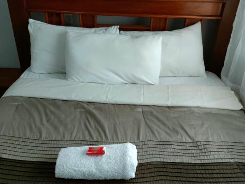 a bed with a white towel and a red box on it at Alken Homes - Two Bedroomed, Naivasha in Naivasha