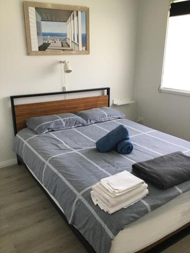 a bedroom with a bed with towels on it at The Jervis Bay Villas in Vincentia