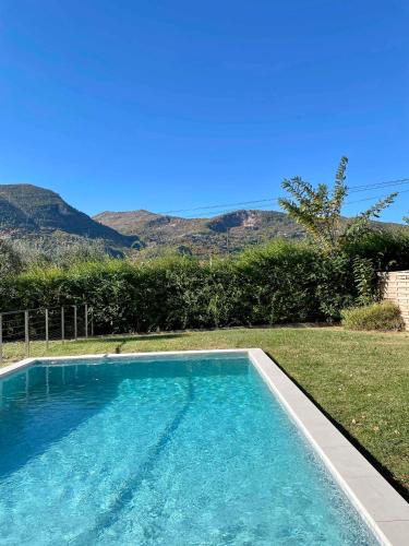- une piscine dans une cour avec des montagnes en arrière-plan dans l'établissement Villa Eugénie, à Saint-Martin-du-Var