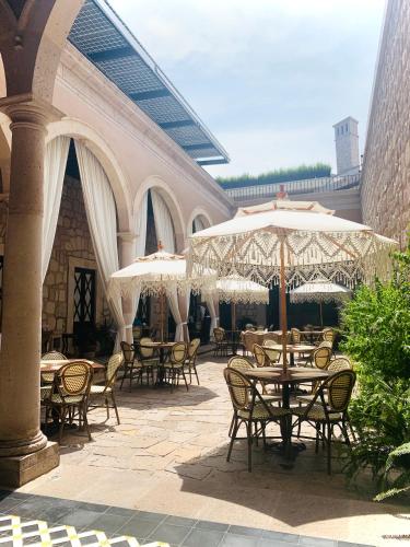an outdoor patio with tables and chairs and umbrellas at Casa Vieja Hotel Boutique in Morelia