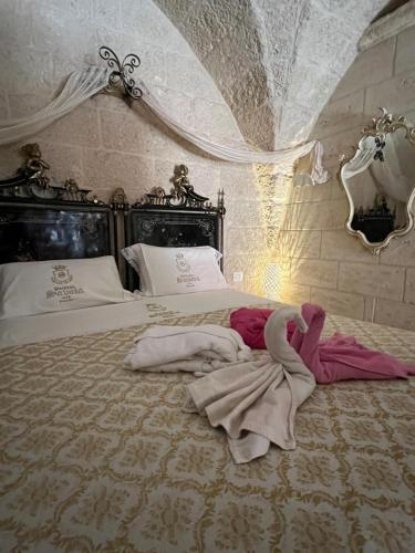 a bedroom with a bed with a robe on it at Palazzo Savoia 1856 in Fasano