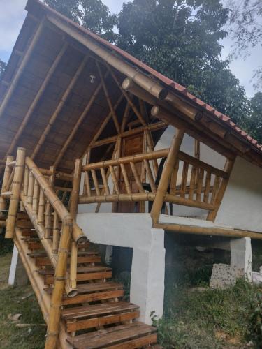 a house with a wooden roof and stairs at El Refugio del Oso de Anteojos in Fómeque