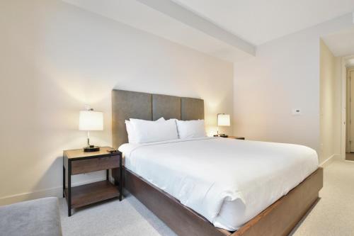 a bedroom with a large white bed and two lamps at Lift Park City Condominiums in Park City