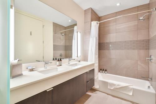 a bathroom with two sinks and a tub and a mirror at Lift Park City Condominiums in Park City