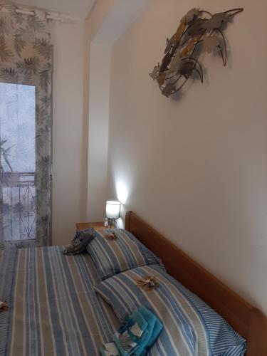 ein Schlafzimmer mit einem Bett mit einem Fisch an der Wand in der Unterkunft Ciuri Ciuri - sea of Taormina in Letojanni