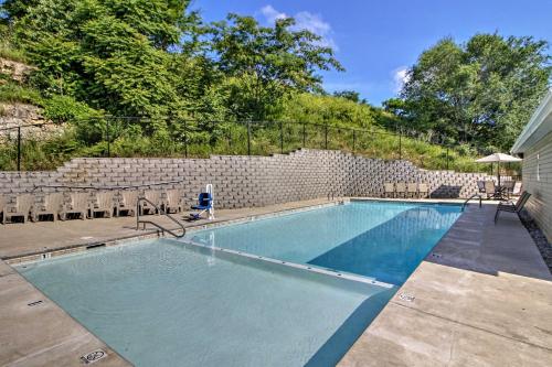 a swimming pool in front of a brick wall at 5 Mi to Marvel Cave Ground-Level Branson Apt! in Branson