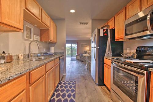 a kitchen with wooden cabinets and stainless steel appliances at 5 Mi to Marvel Cave Ground-Level Branson Apt! in Branson