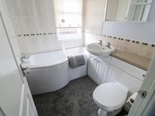 里士滿的住宿－16 Badgers Retreat，白色的浴室设有卫生间和水槽。