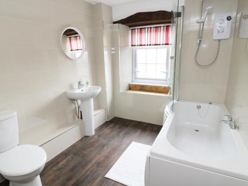 uma casa de banho branca com um WC e um lavatório em Hope Cottage em Leyburn