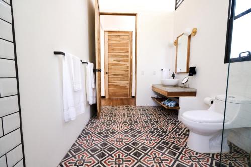 a bathroom with a toilet and a sink at La Prometida in Puerto Viejo