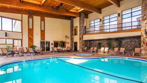 uma piscina num hotel com cadeiras e mesas em Best Western Center Pointe Inn em Branson